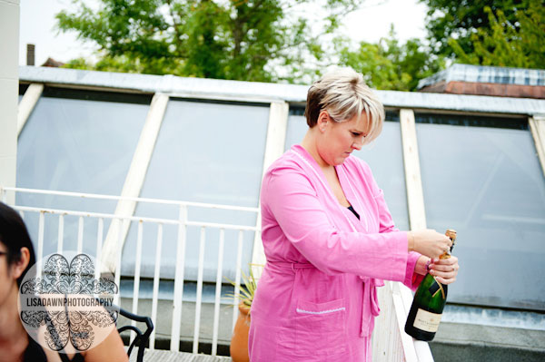 Bridesmaid popping open the champagne