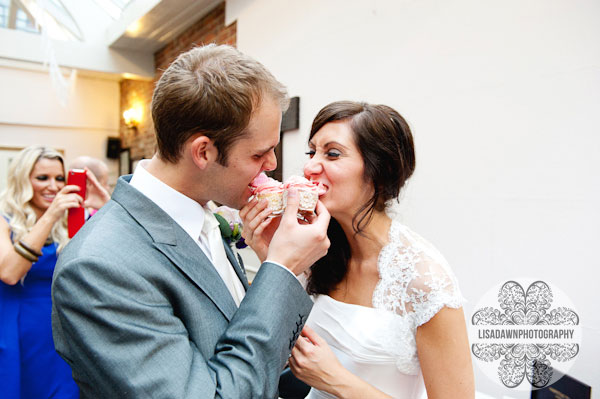 bride and groom eating cupcakes