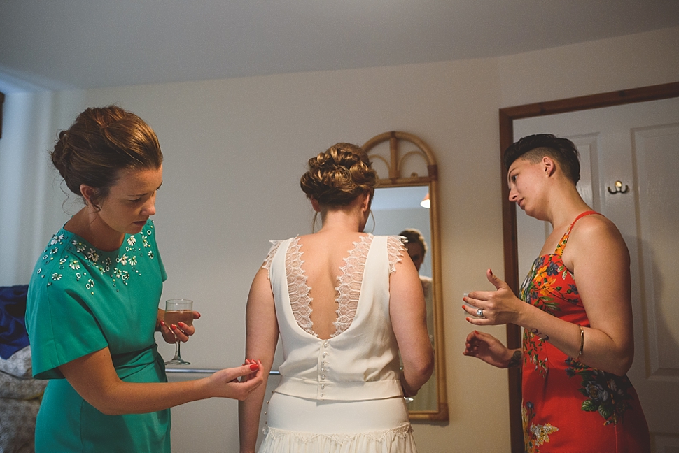 Bride putting on wedding dress