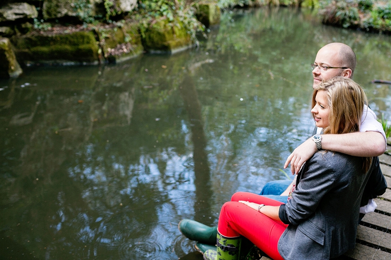 couple sitting beside lake