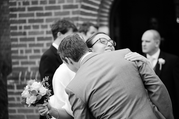 Bridesmaid hugs groom