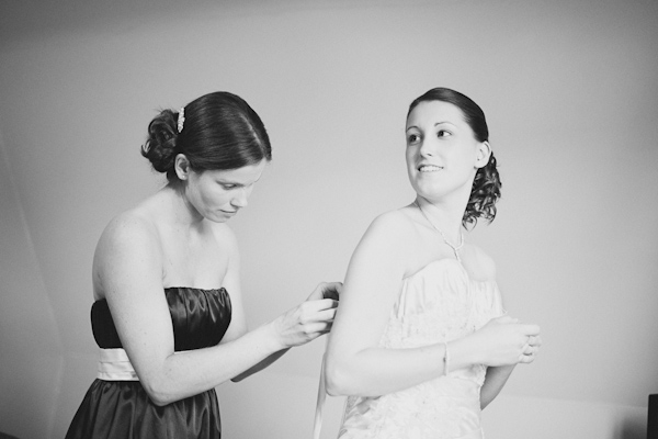 bridesmaid putting on wedding dress